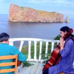 a photo of Reza and Fili performing in the Gaspe on a balcony overlooking the sea.