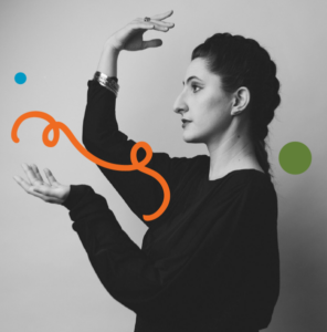 A photo of Liberté-Anne in black clothing and with long dark hair in a braid standing in profile. She is looking straight ahead and holding her hands up and in front of her in a statuesque pose. Image has been filtered in greyscale with colourful dots and a squiggly line added.