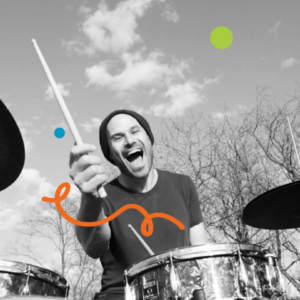 A photo of Raphael Roter playing the drums outdoors with trees in the background. Image has been filtered in greyscale with colourful dots and a squiggly line added.