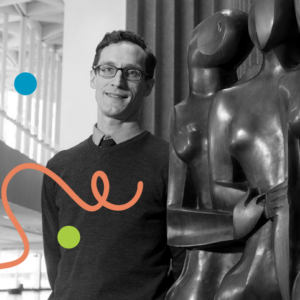 Photo of Robert VanderBerg standing in an atrium next to two abstract sculptural human figures. Image is filtered in greyscale with colourful dots and a squiggly line added.